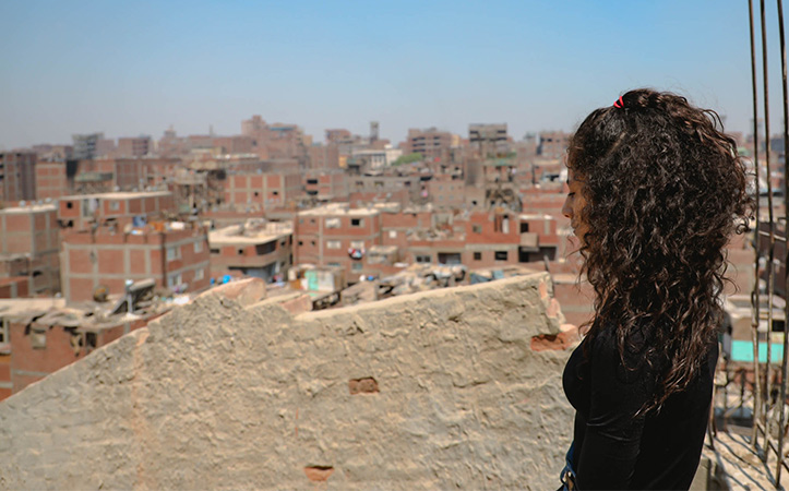 Lockiges Mädchen schaut auf eine zerstörte Stadt