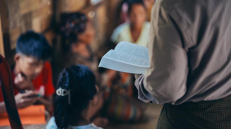 Rücken eines Mannes mit einer Bibel im Arm