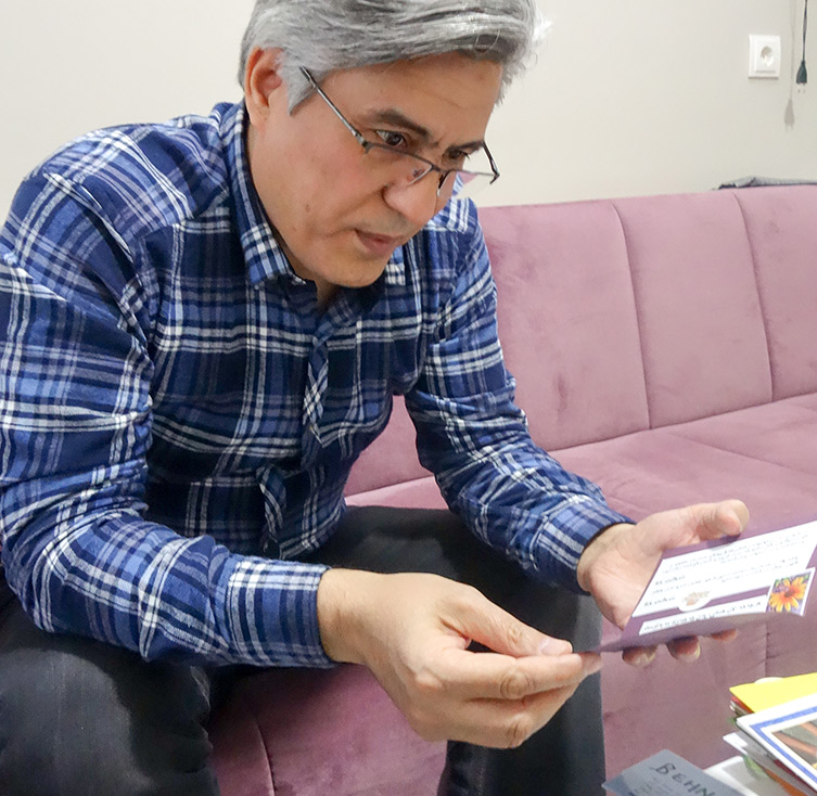 Bild: Behnam Irani liest Ermutigungskarten aus einer Schreibaktion von 2014