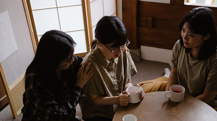 Nordkoreanische Christinnen beten gemeinsam für eine Frau