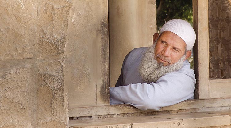 Muslimischer Mann schaut aus dem Fenster