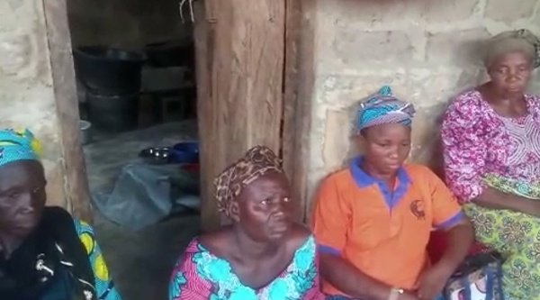 Vier afrikanische Frauen sind vor einer Hauswand
