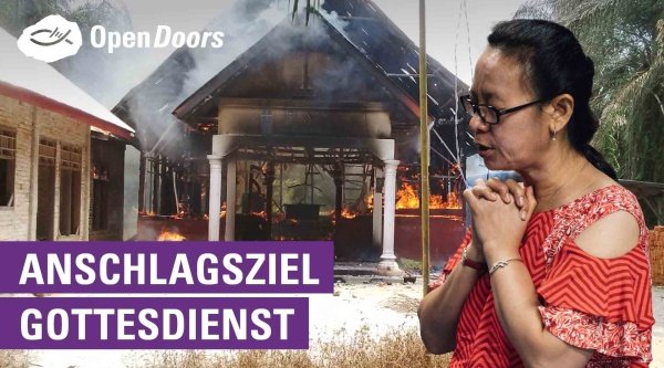 Frau aus Indonesien mit Brille vor brennender Kirche 