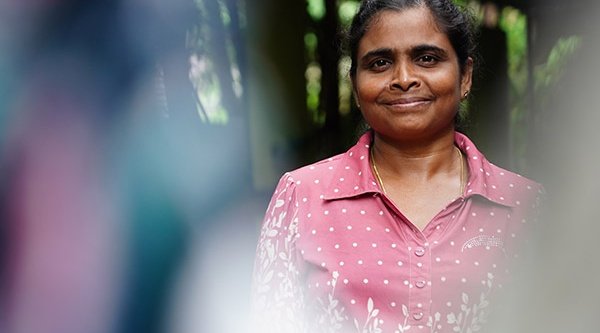 Lächelnde Frau aus Sri Lanka in einer rosafarbenen Bluse