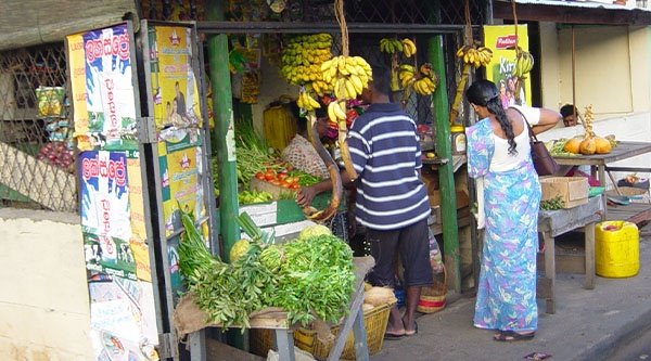 Zwei Personen stehen vor einem Obstmarkt