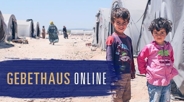 Zwei Kinder stehen vor einer Zeltstadt in einem Flüchtlingslager.