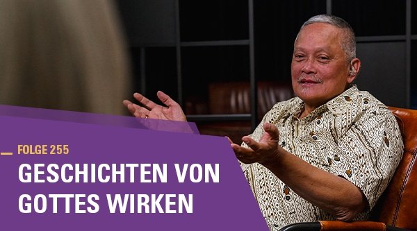 Ein Mann sitzt auf einem Ledersessel in einem Fernsehstudio.